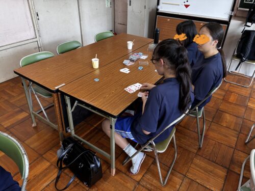 放課後のサロンでカードを囲む中学生たち
